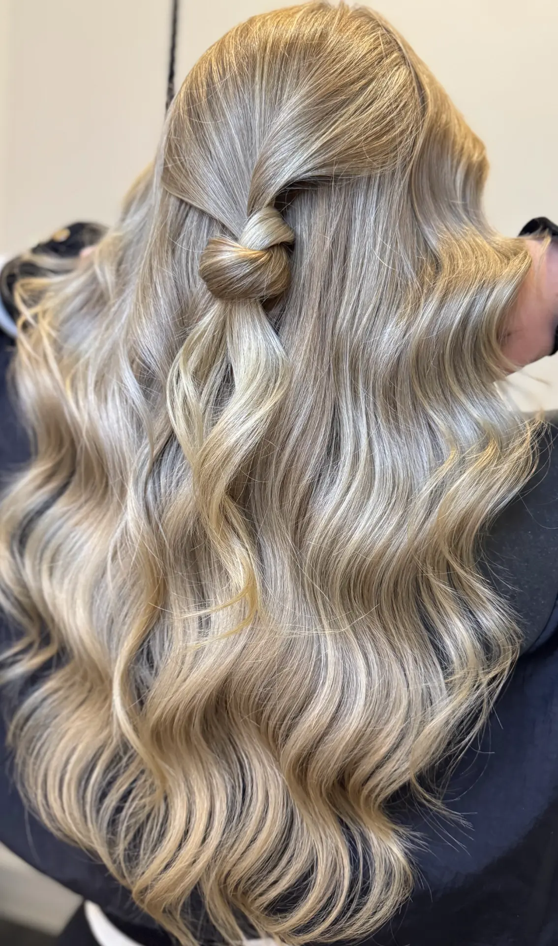 Glanzend blond gegolfd haar met knot van achteren